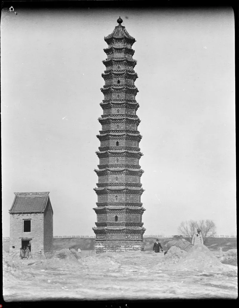甘博拍摄的开封铁塔近景，塔前可见人物、土堆与小楼，约 1919 年